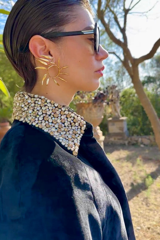 The Golden Collar Cape in black silk velvet with golden sequin collar, collar close-up in profile, garden