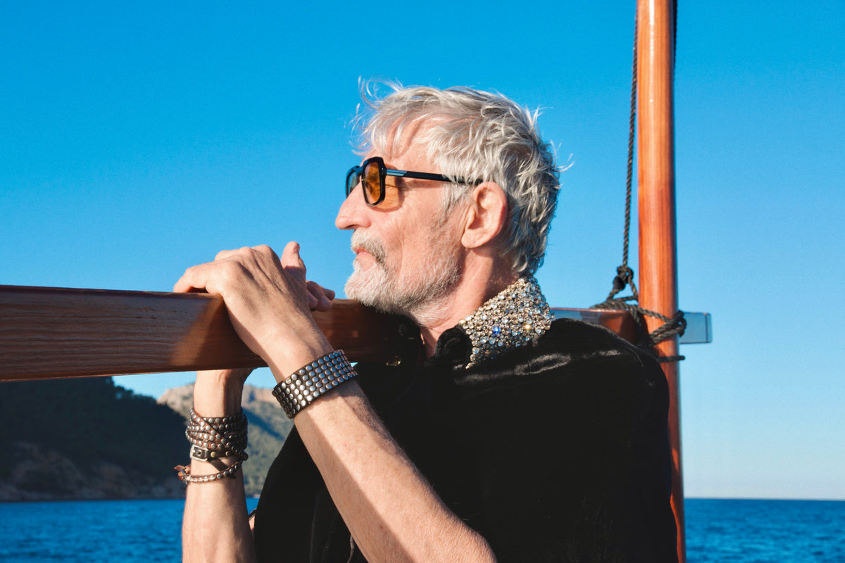 The Golden Collar Cape in black silk velvet with golden sequin collar, collar detail, on a sailing boat