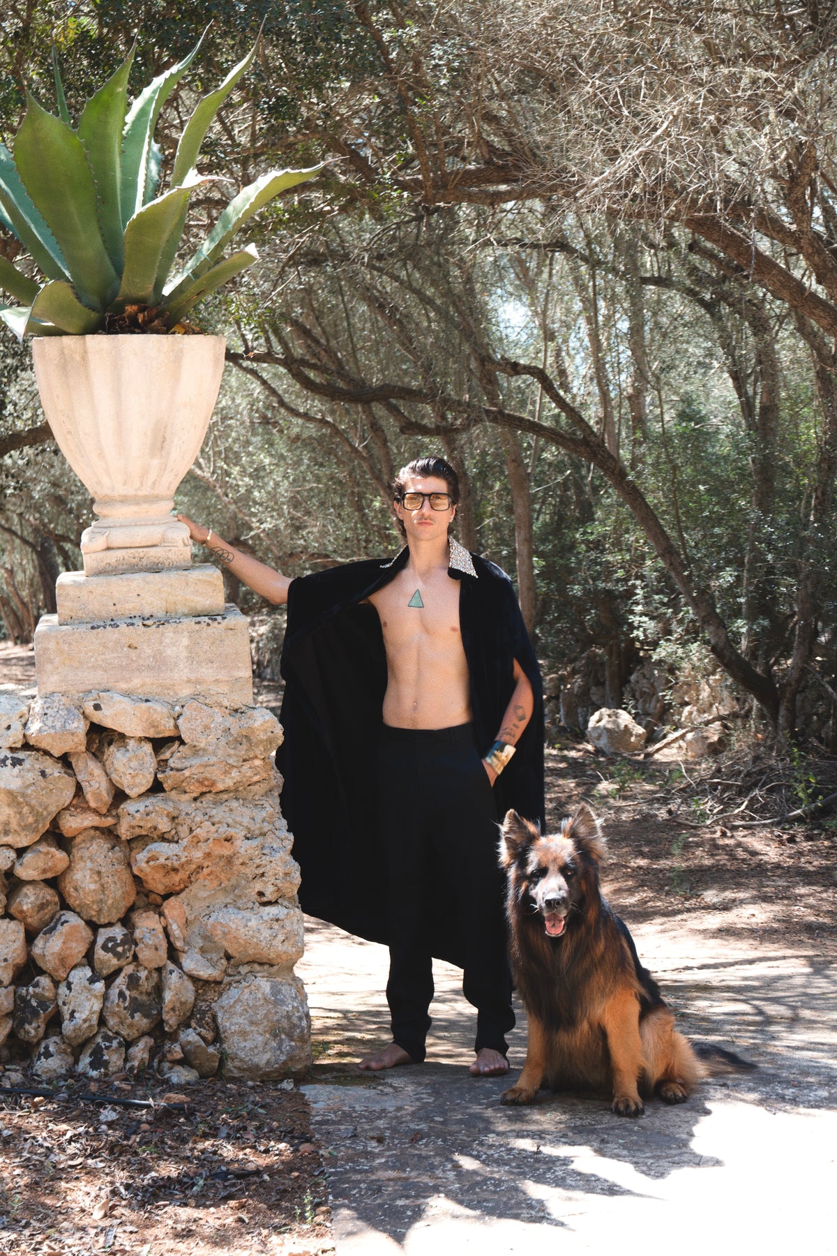 The Golden Collar Cape in black silk velvet with golden sequin collar, worn open in a garden