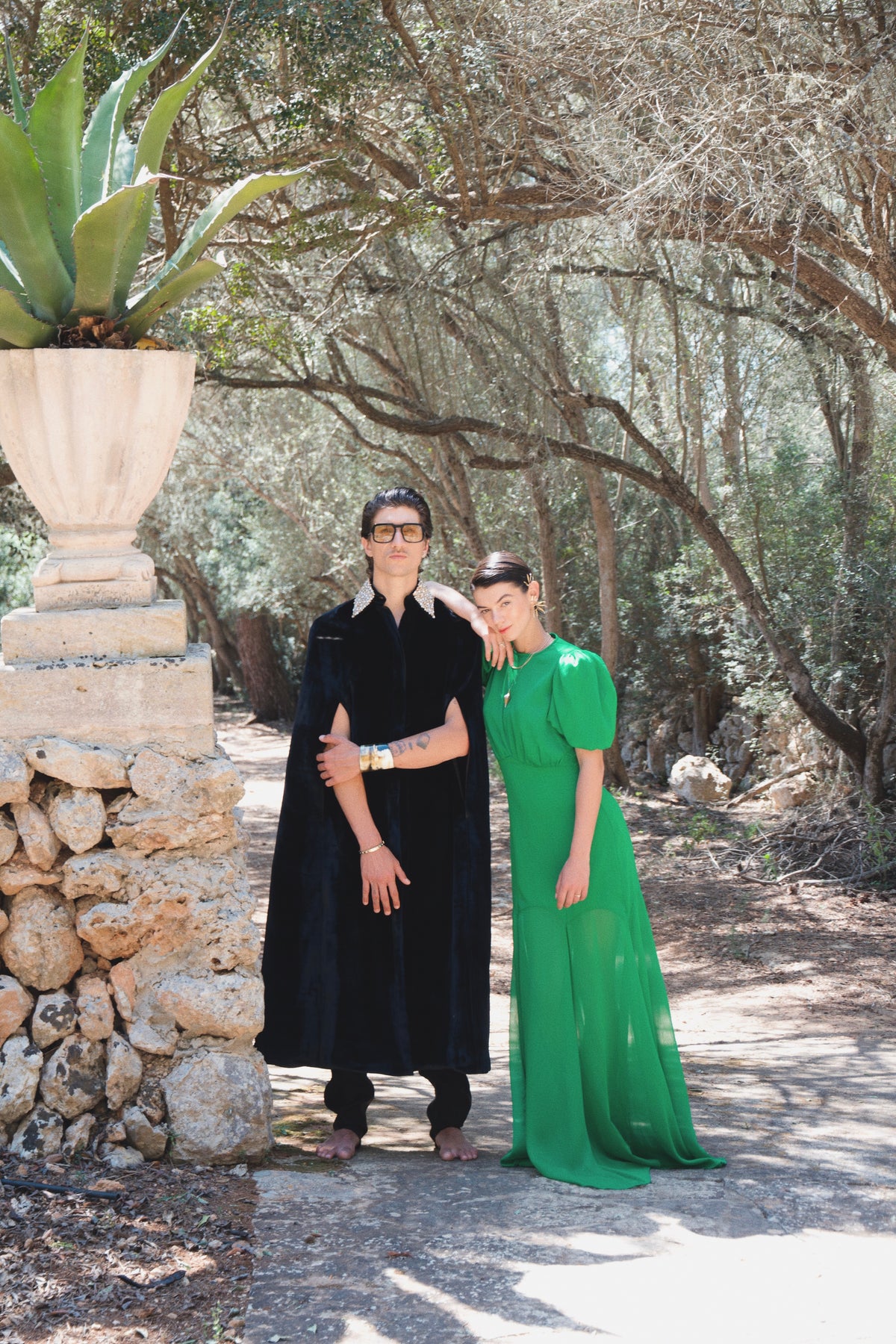 The Golden Collar Cape in black silk velvet with golden sequin collar, worn with a green dress, olive grove