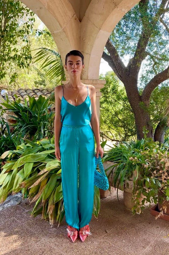 The Blue Poppy Camisole in turquoise silk, with matching trousers, front view, garden archway
