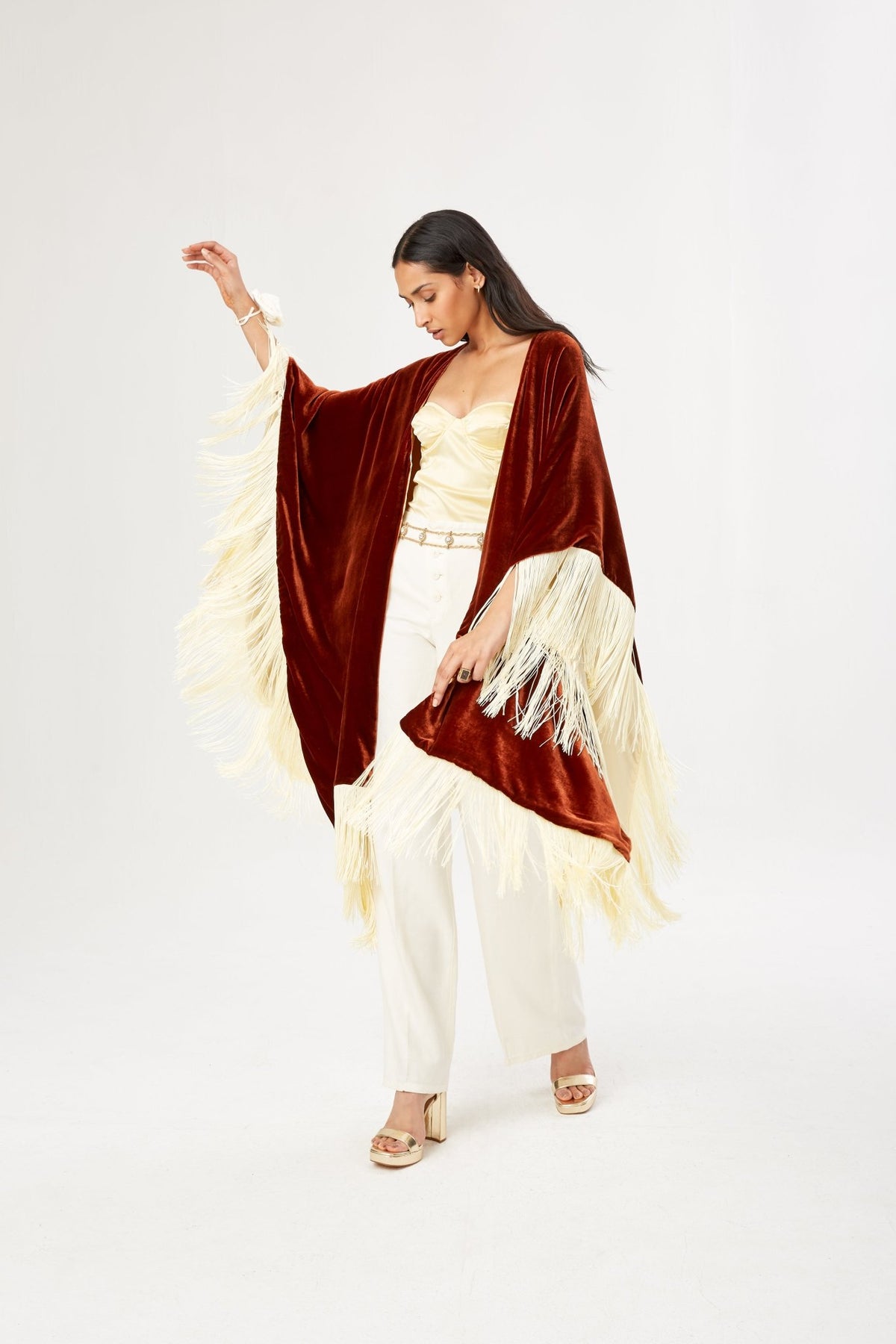 The Bronze Poncho in bronze silk velvet with cream fringe, in motion, studio
