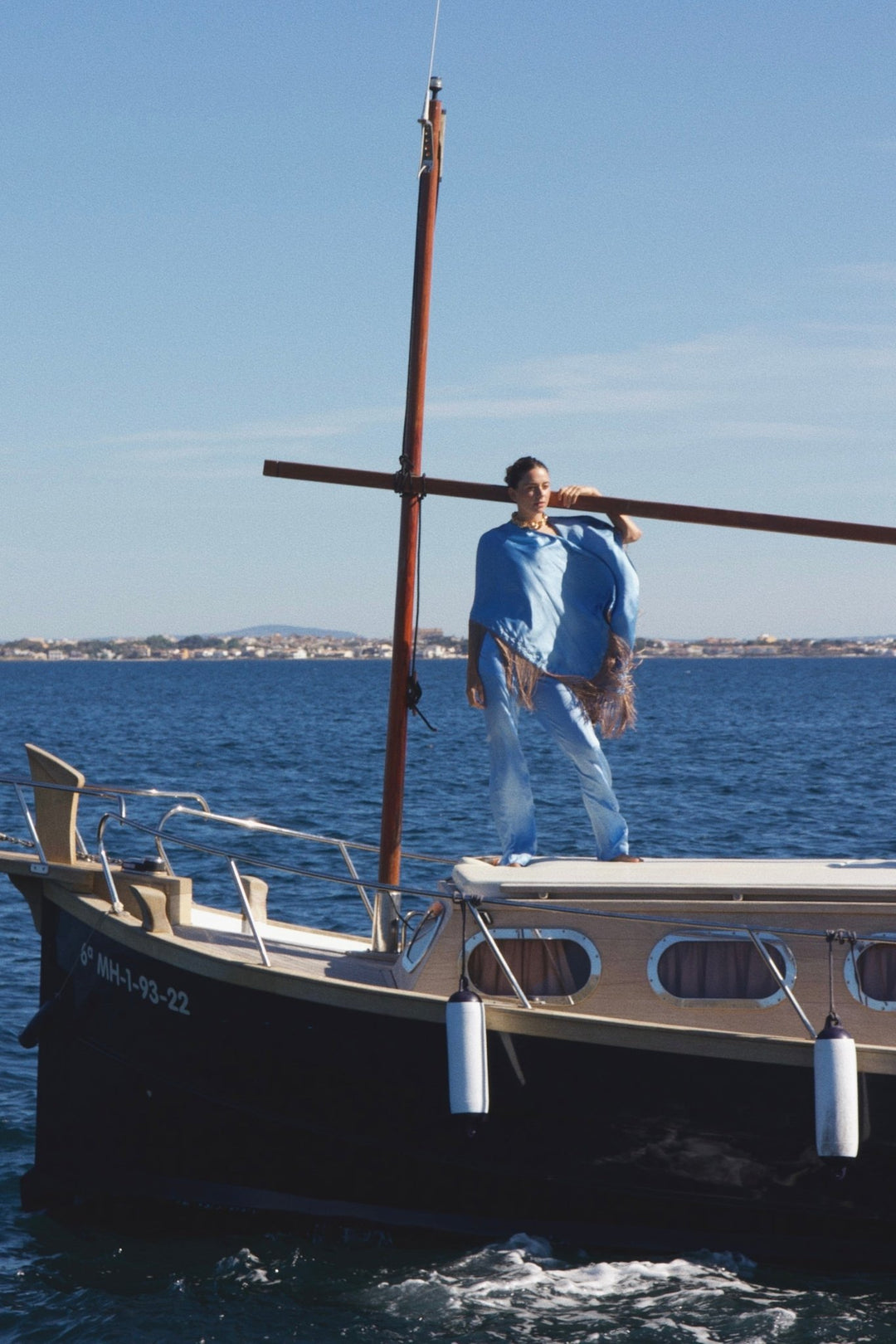 The Cornflower Trousers in powder blue silk, on a sailing boat at sea