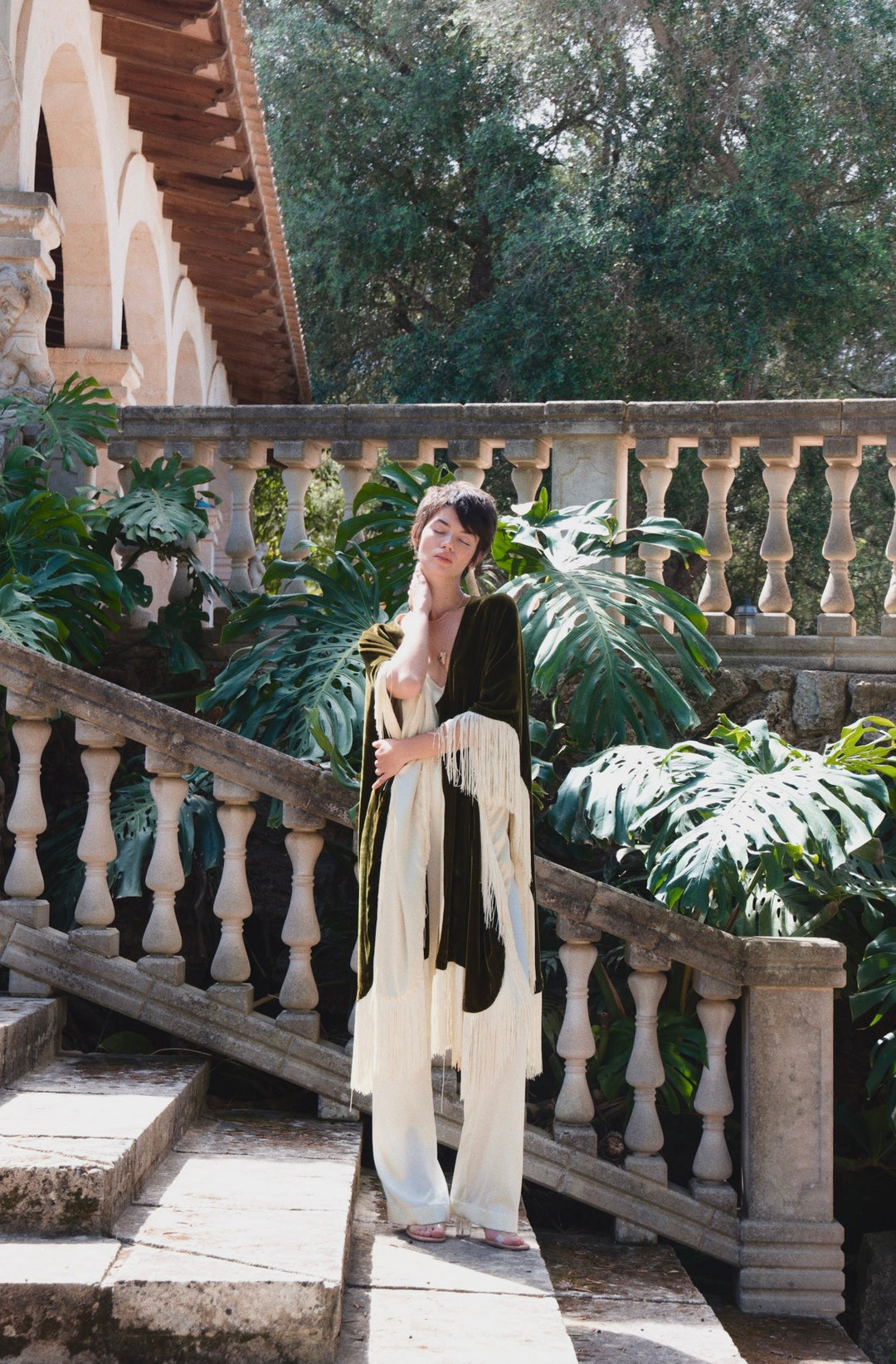 The Cream White Camisole in cream silk, styled with the Evergreen Poncho, stone staircase