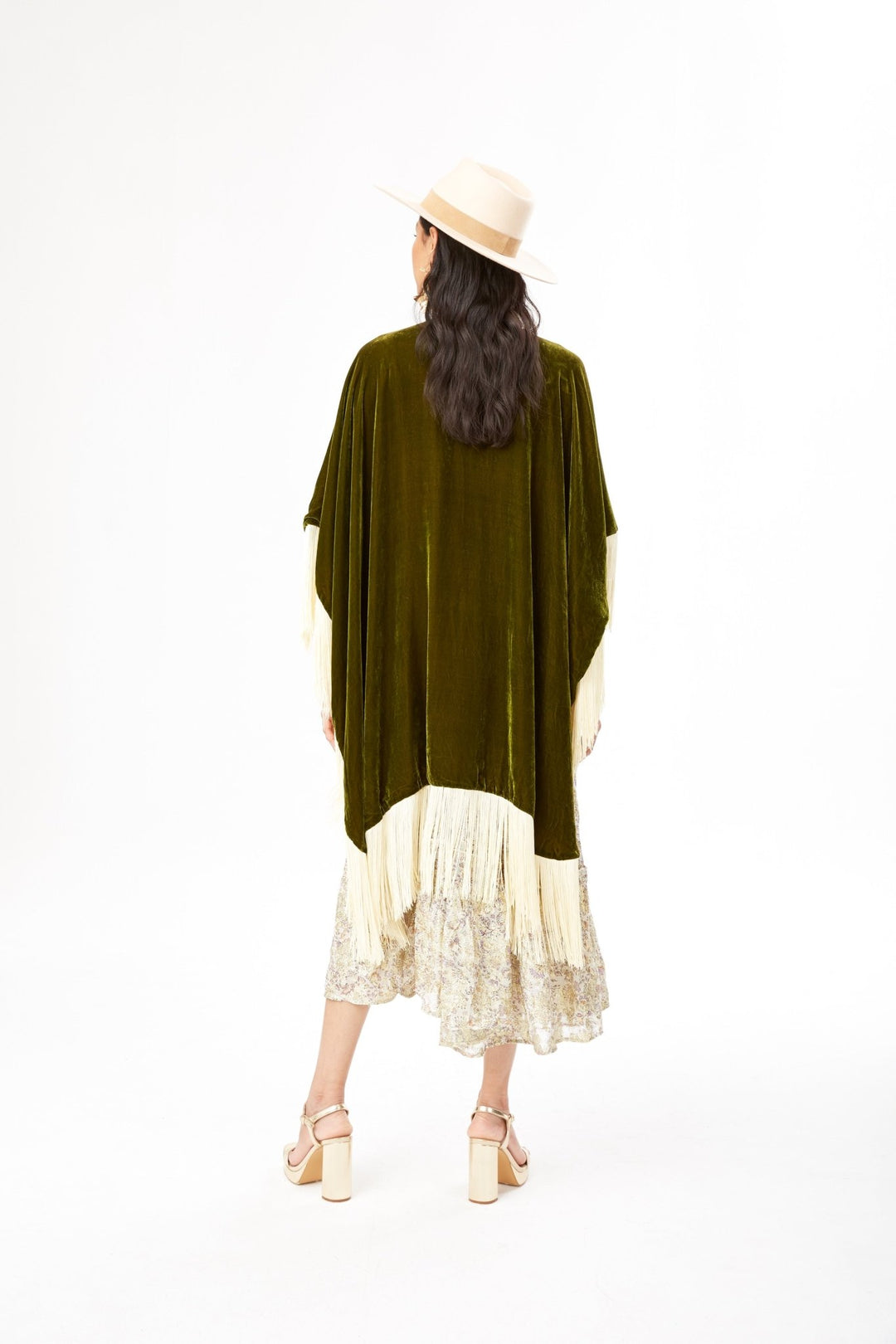 The Evergreen Poncho in olive green silk velvet with cream fringe, back view, studio