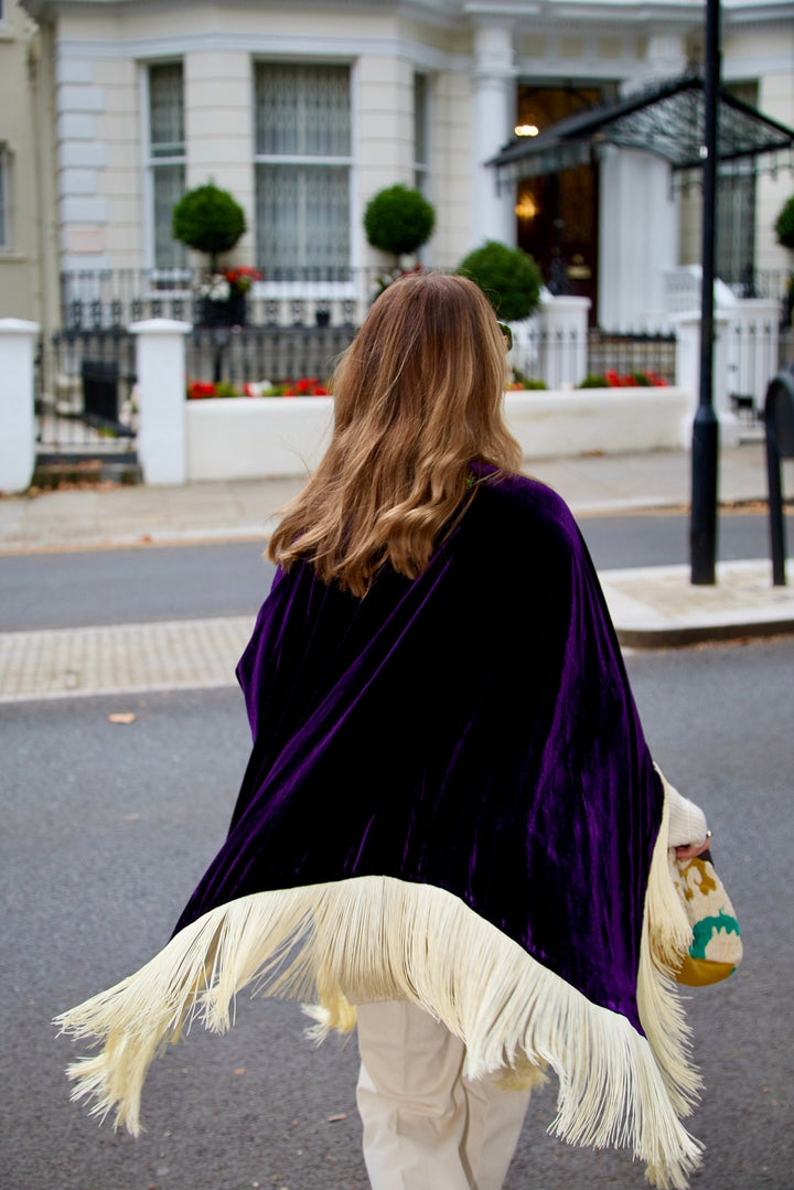 The Gatsby Poncho in purple silk velvet with champagne fringe, back view, London street