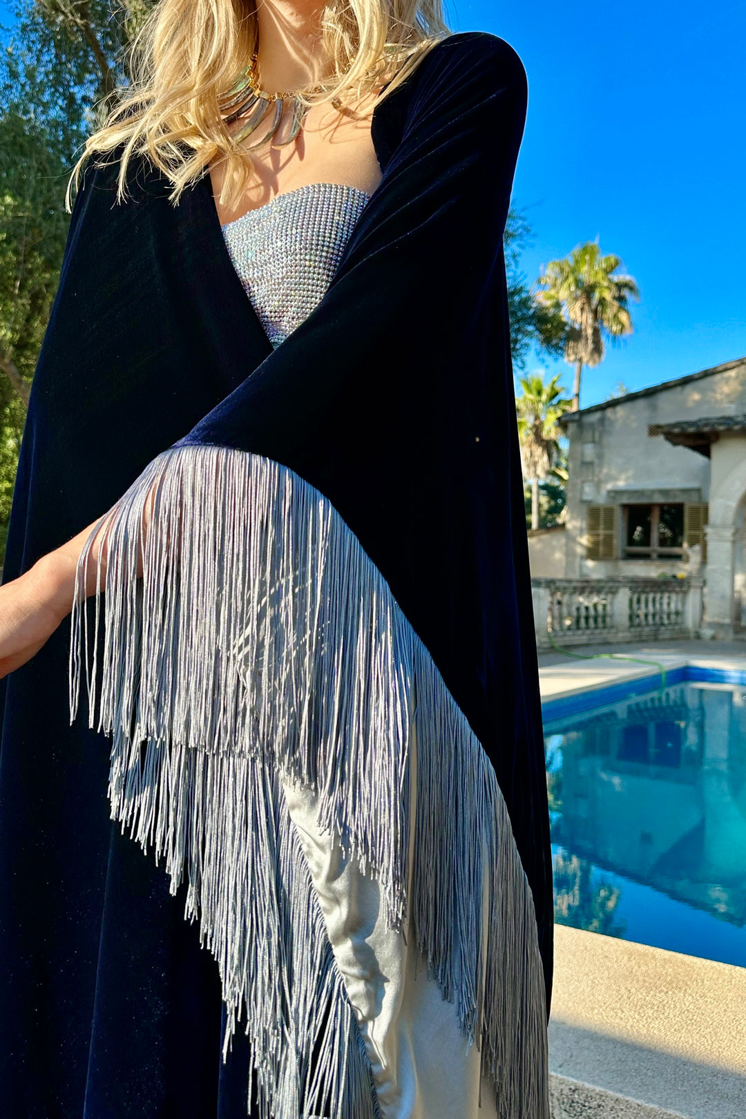 The Glory of the Snow Poncho in midnight blue silk velvet with silver fringe, fringe detail, poolside
