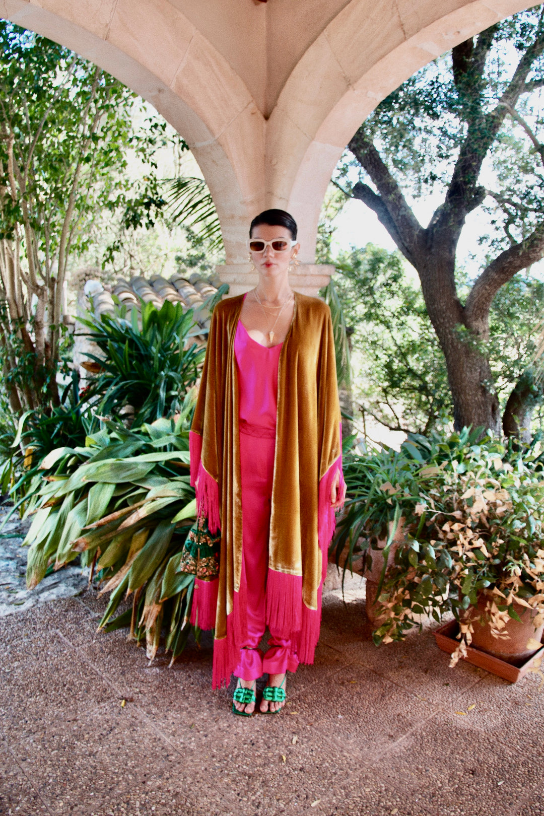 The Hot Pink Trousers in hot pink silk, styled with the Limoncello Poncho, garden archway