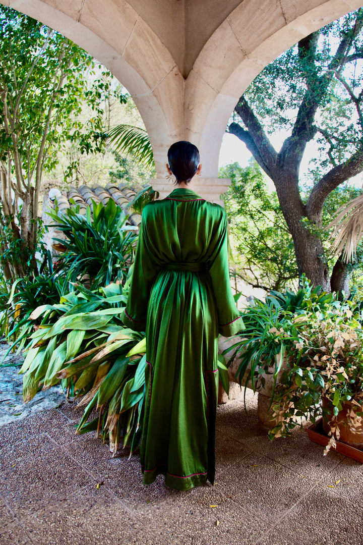 The Jade Vine Kimono in emerald green heavy silk, back view, garden archway