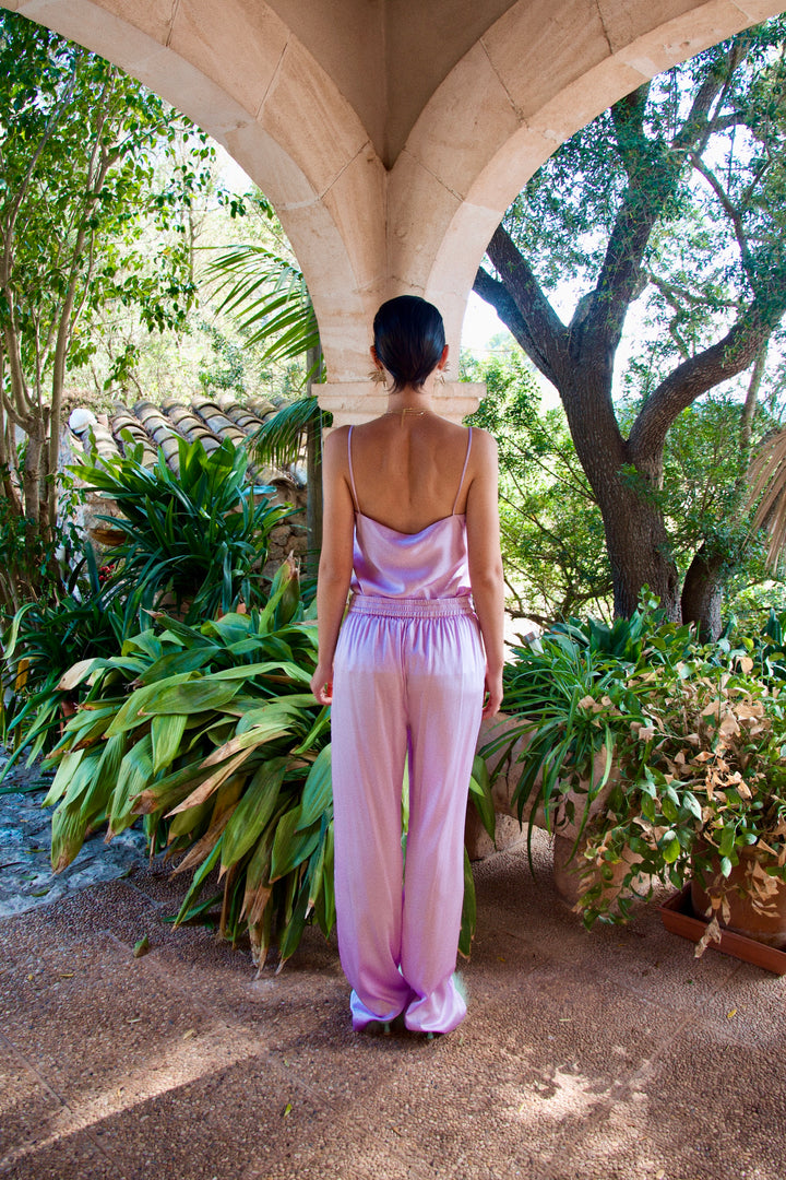 The Lavender Trousers in lavender silk, back view, garden archway