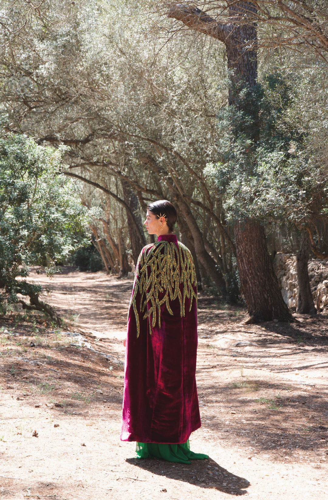 The Royal Garden Cape in magenta silk velvet with gold and green leaf embroidery, back view, olive grove