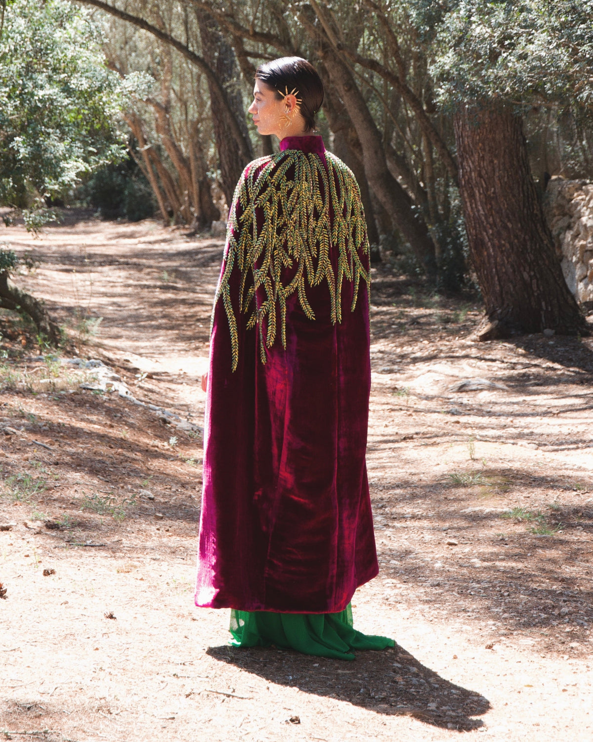 The Royal Garden Cape in magenta silk velvet with gold and green leaf embroidery, back view, olive grove