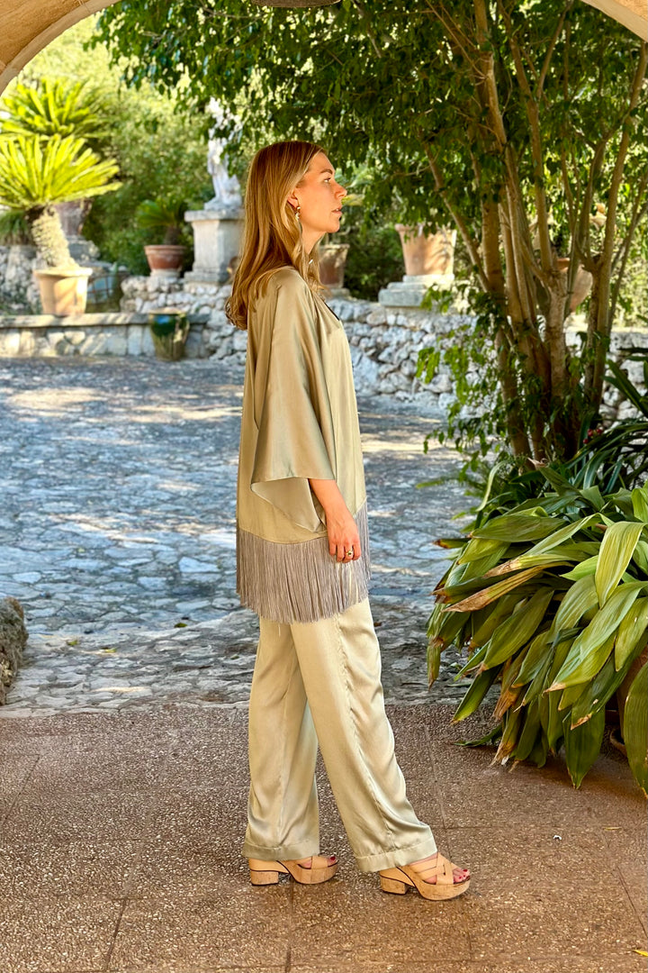 The Sage Trousers in sage silk, styled with the Sage Leaf Kimono, garden courtyard
