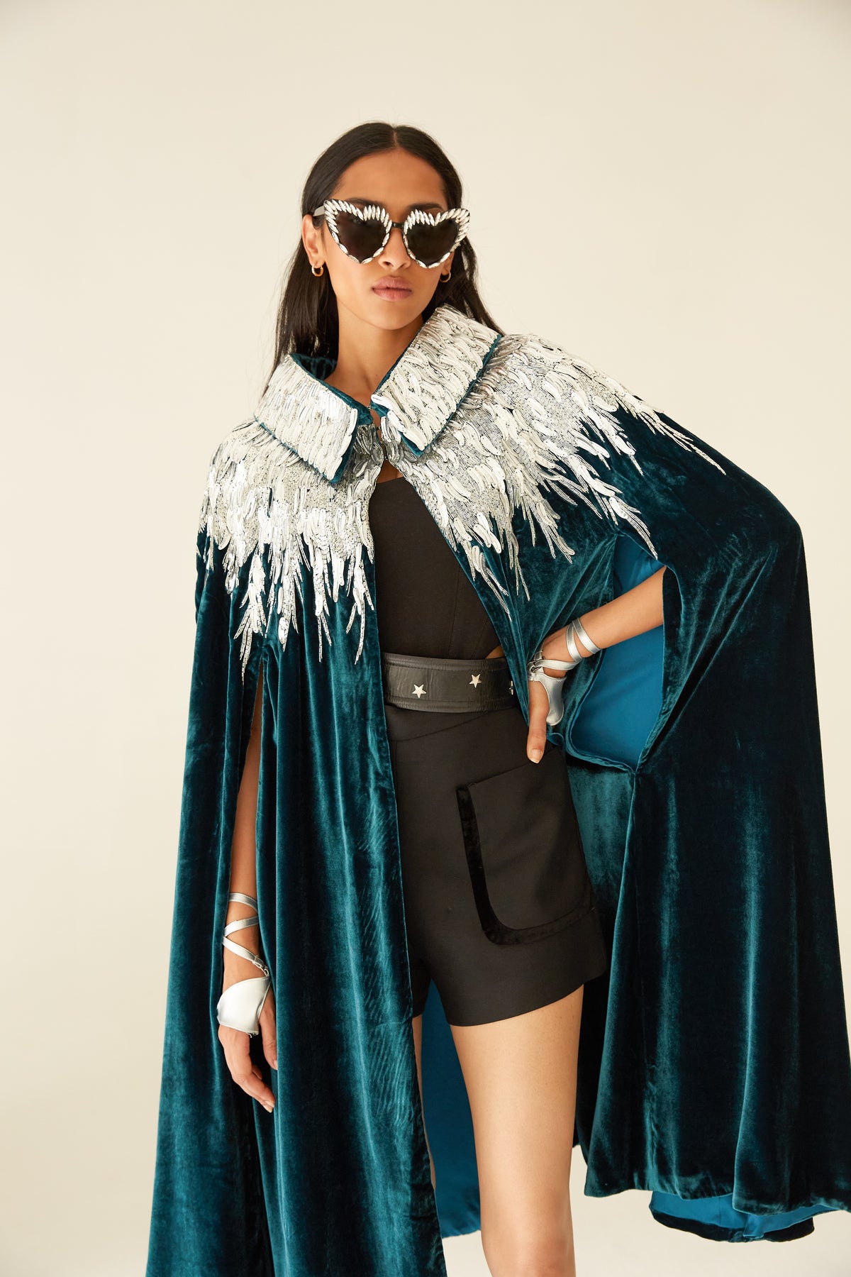 The Silver Feather Cape in petrol silk velvet with silver beaded feathers, three-quarter view, studio