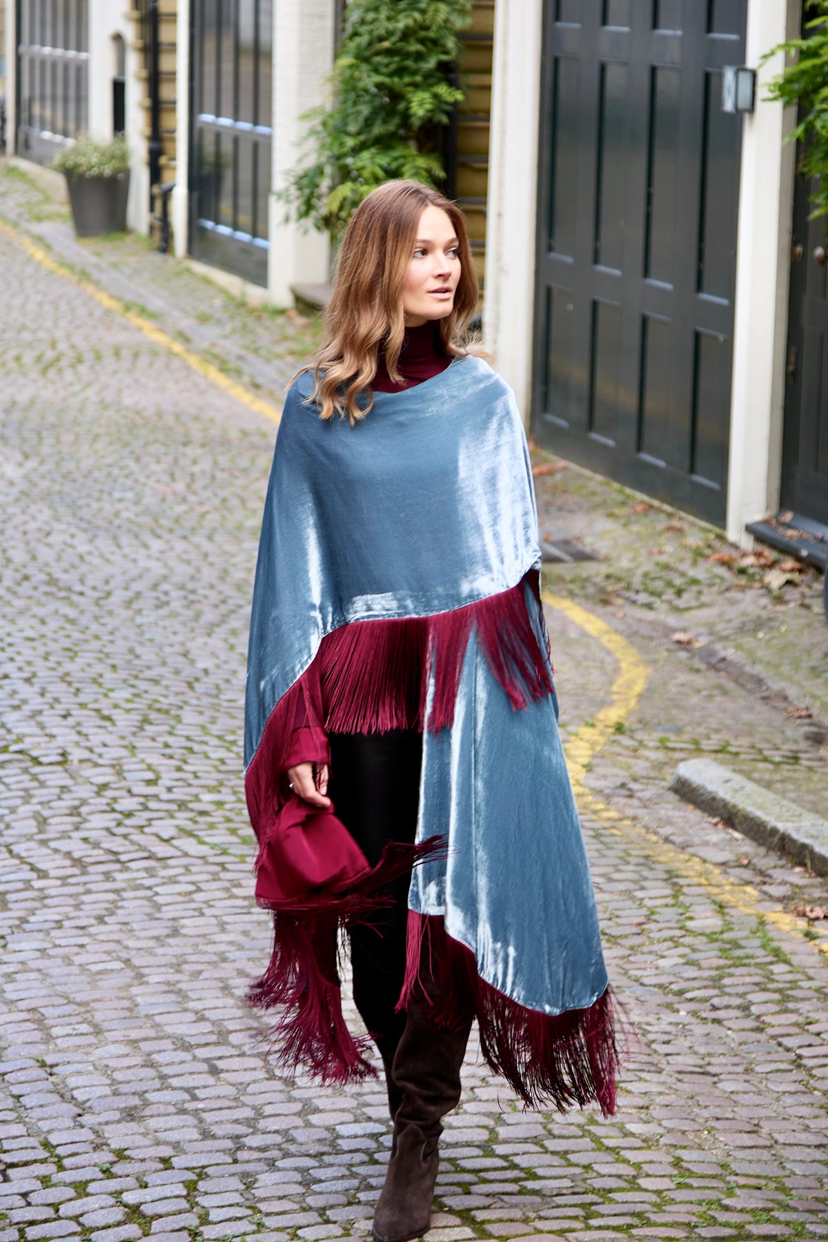 The Summer Cloud Poncho in pale blue silk velvet with burgundy fringe, walking, cobbled mews