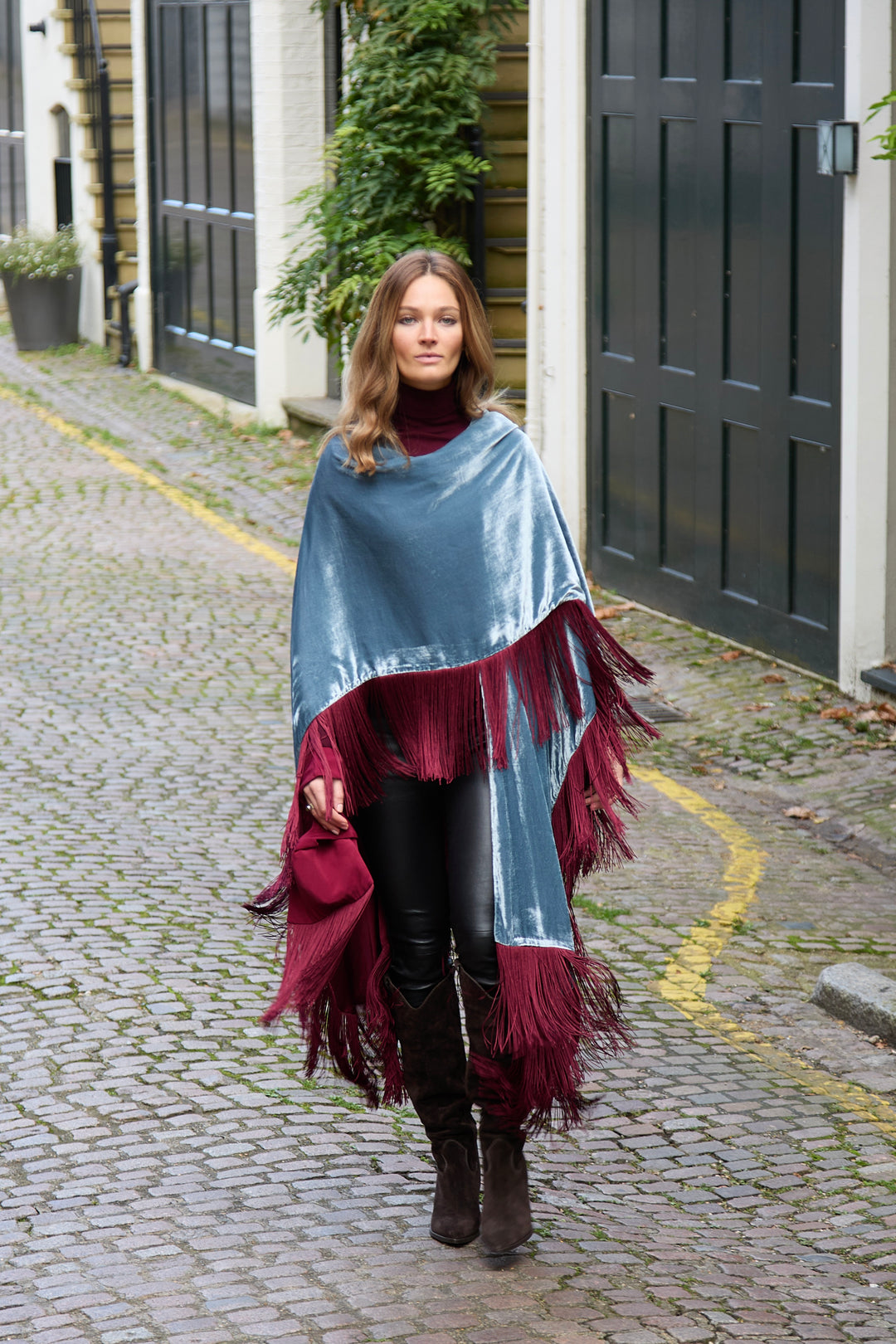 The Summer Cloud Poncho in pale blue silk velvet with burgundy fringe, walking, cobbled mews