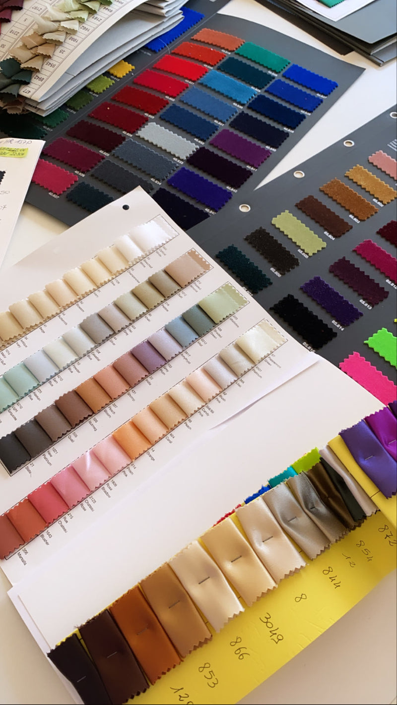 Silk colour swatch books open in the atelier, hundreds of shades