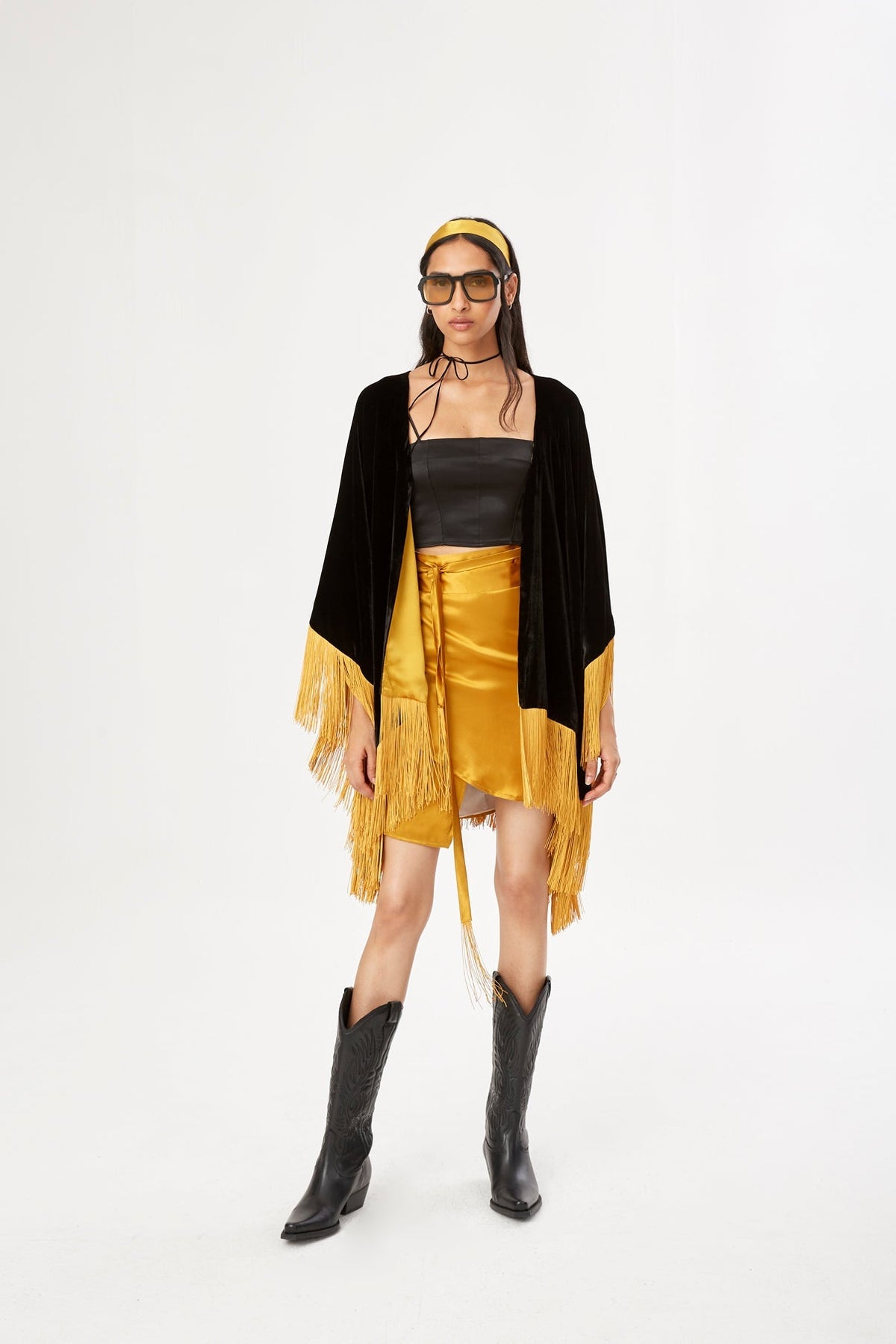 The Golden Age Poncho in black silk velvet with gold fringe, front view, studio