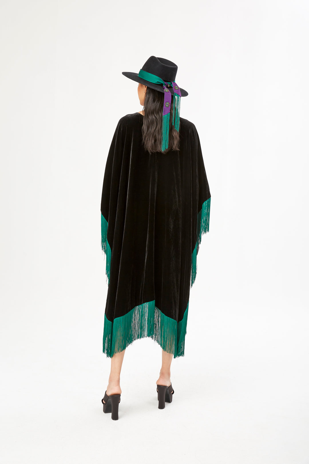 The Gypset Poncho in black silk velvet with emerald fringe, back view, studio