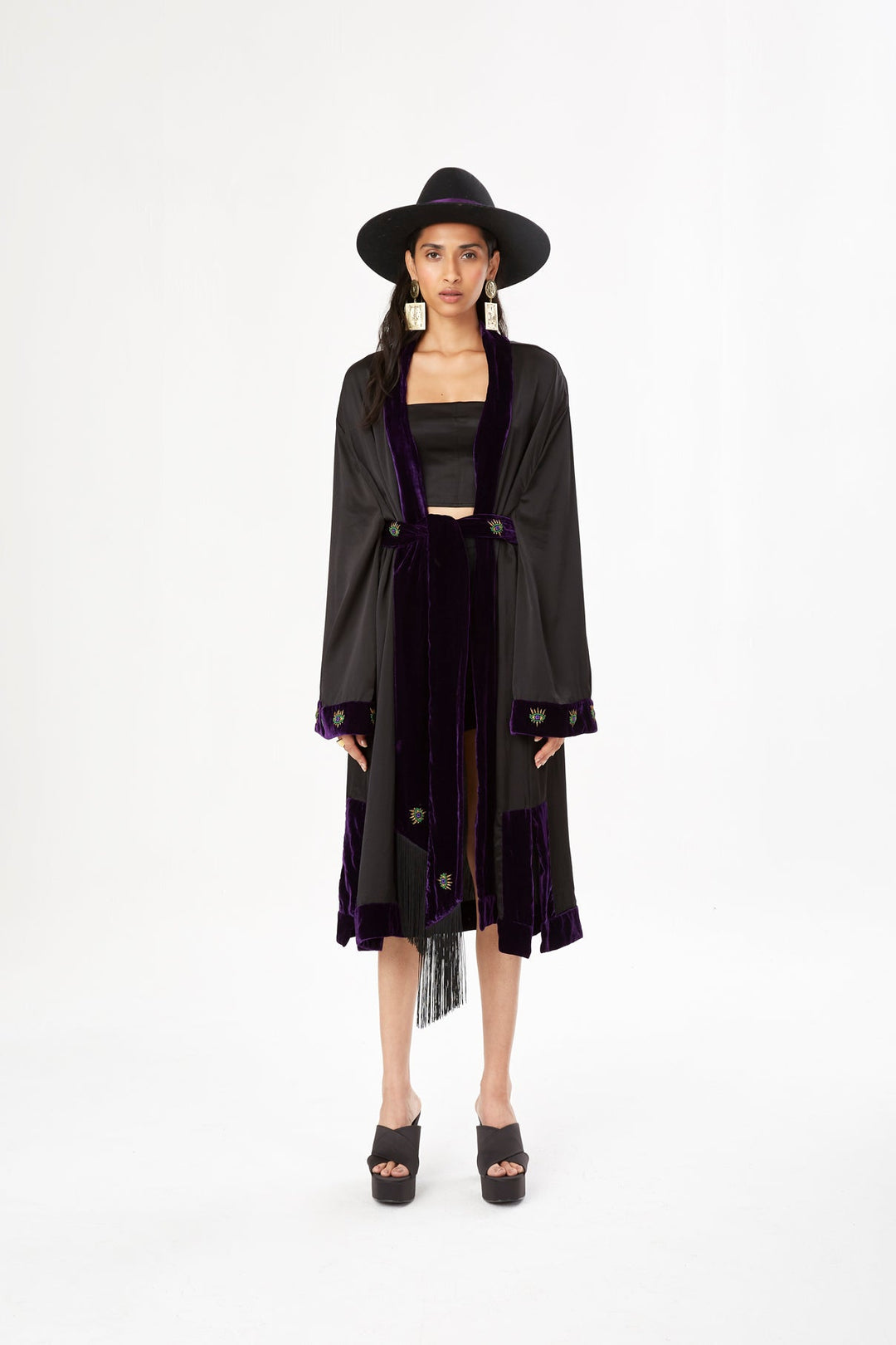 The Midnight Kimono in black silk with purple velvet trim and embroidery, front view with black hat, studio