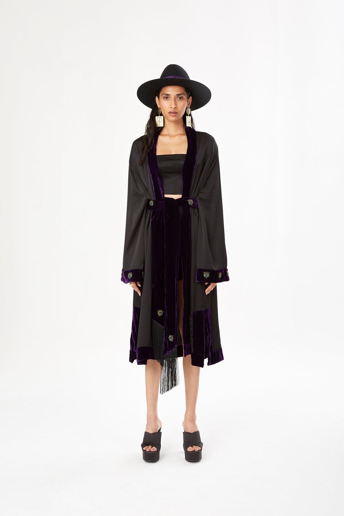 The Midnight Kimono in black silk with purple velvet trim and embroidery, front view with black hat, studio