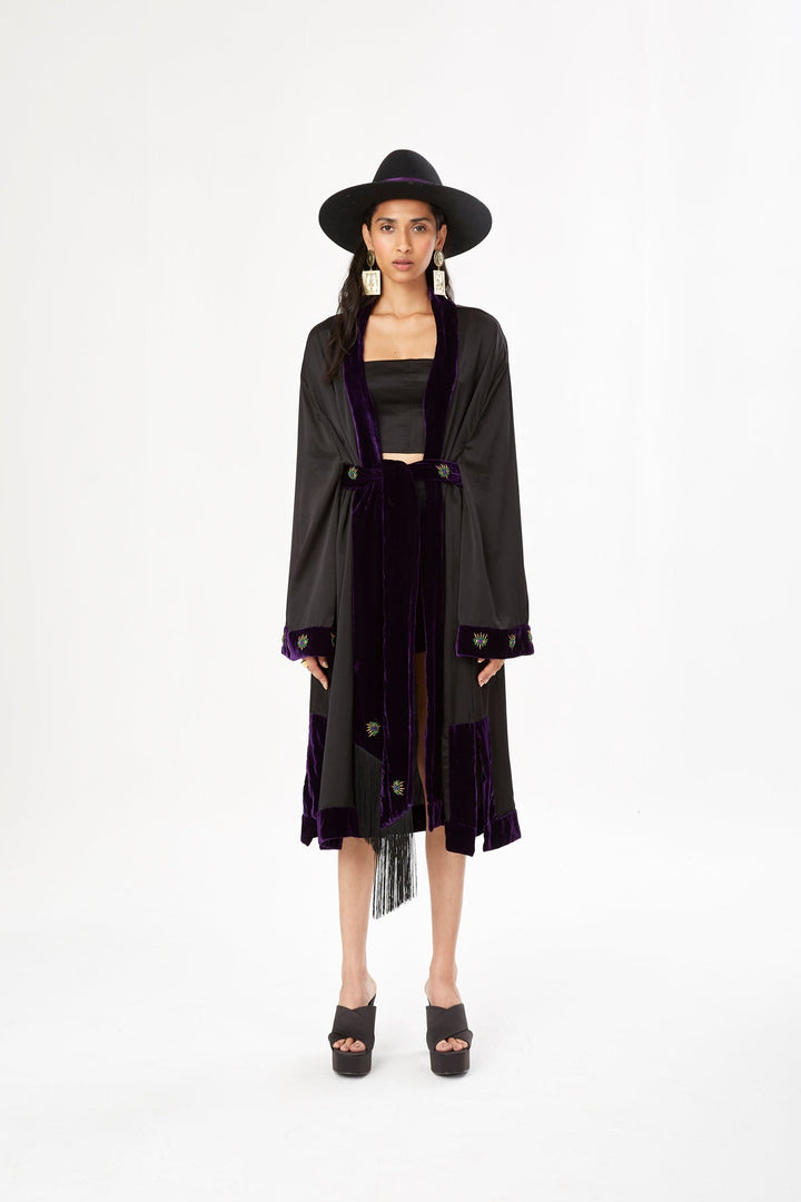 The Midnight Kimono in black silk with purple velvet trim and embroidery, front view with black hat, studio
