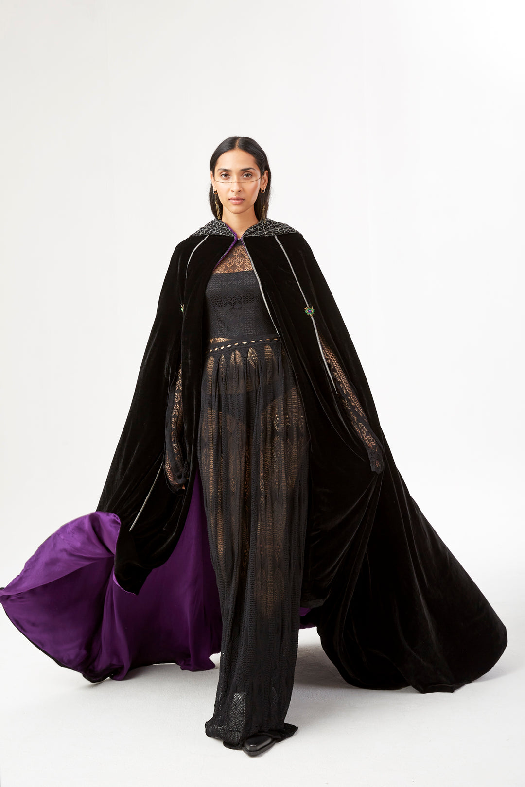 The Mystery Cape in black silk velvet with purple lining and embroidered hood, front view, studio