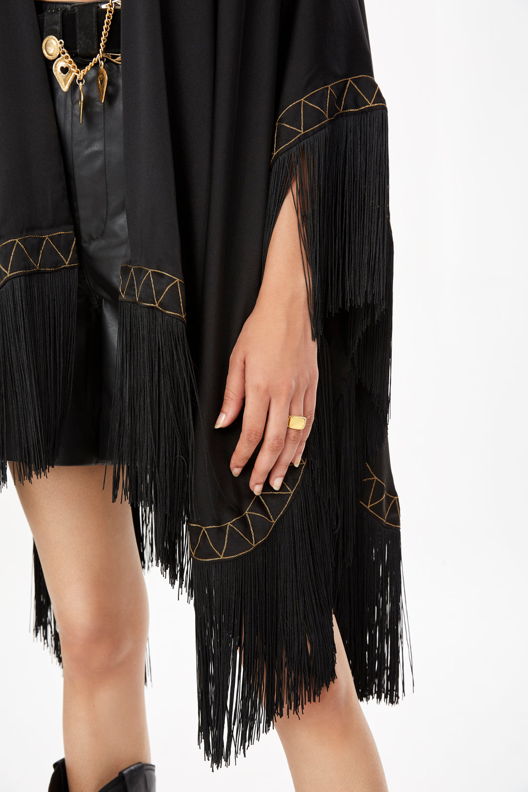 The Nomad Poncho in black silk with gold hand embroidery and black fringe, embroidery and fringe detail, studio