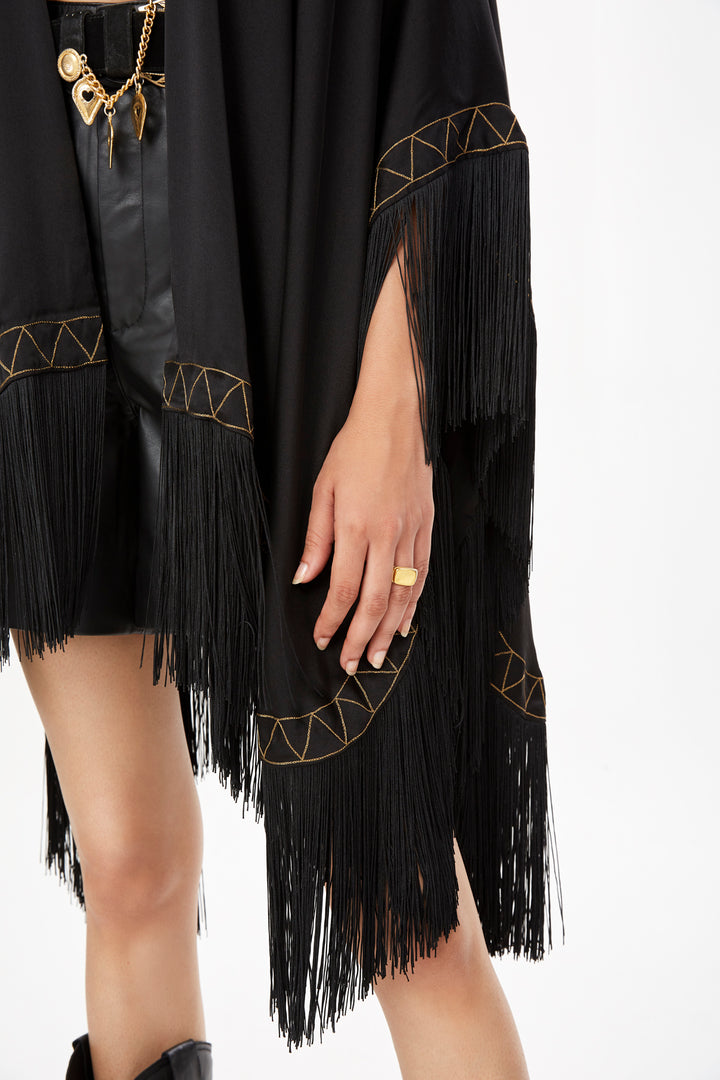 The Nomad Poncho in black silk with gold hand embroidery and black fringe, embroidery and fringe detail, studio