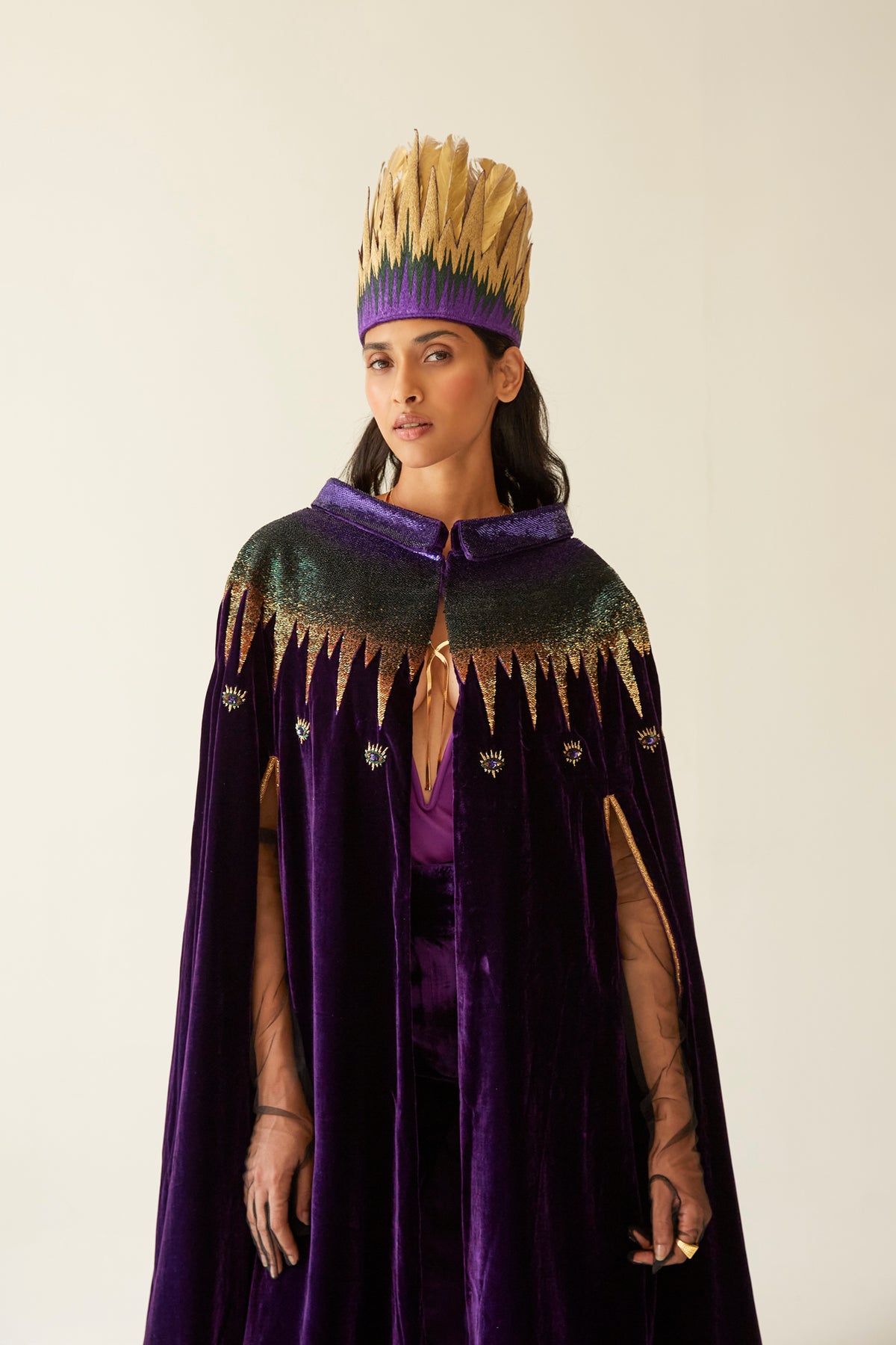 The Rainbow Feather Headdress with golden feathers on a purple band, side view, studio