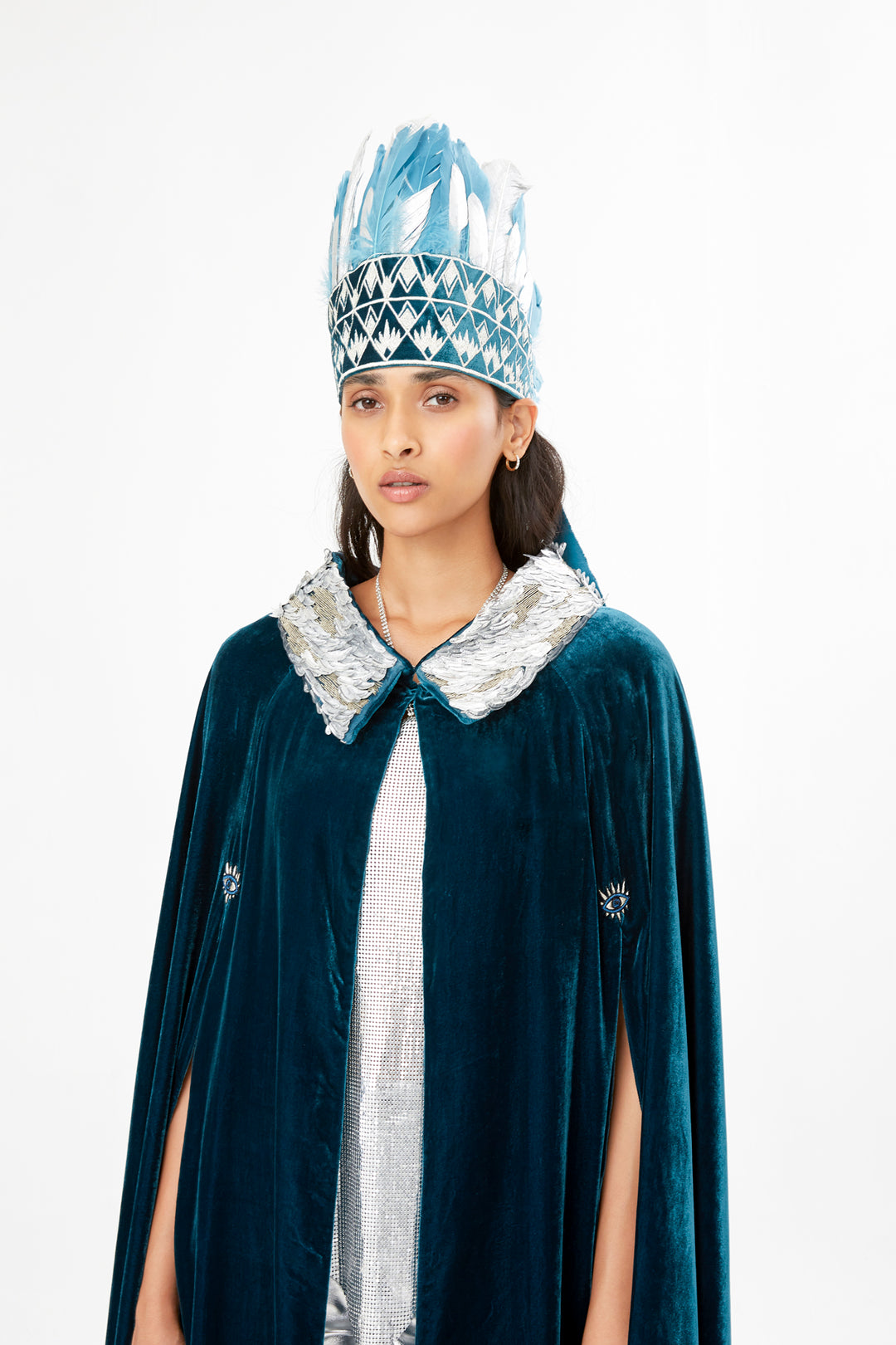 The Silver Feather Headdress with silver and pale blue feathers, styled with the Shining Collar Cape, front view, studio